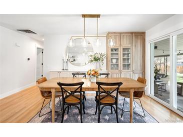 Elegant dining space with hardwood floors, chic lighting, and a seamless transition to outdoor entertaining at 3560 S Glencoe St, Denver, CO 80237