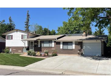 Charming brick home with a well-maintained front yard, driveway, and attached garage at 1299 S Brentwood Way, Lakewood, CO 80232