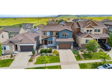 Beautiful two-story home with a blue exterior, well-manicured lawn, and a two-car garage at 18180 W 84Th Pl, Arvada, CO 80007
