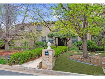 Charming two-story brick home with a lush, landscaped front yard and a stone mailbox at 4070 S Hudson Way, Englewood, CO 80113