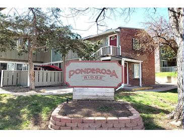 A view of the Ponderosa Ridge entrance sign on a sunny day with multiple housing units visible in the background at 857 S Van Gordon Ct # I207, Lakewood, CO 80228