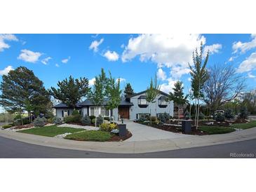 Charming two-story home with beautifully landscaped front yard and blue skies at 4218 S Alton St, Greenwood Village, CO 80111