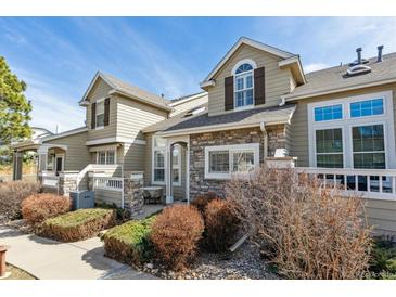 Inviting exterior with stone accents, manicured landscaping and a charming covered entry, bathed in natural light at 6237 Trailhead Rd, Highlands Ranch, CO 80130