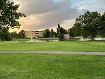 Scenic golf course view featuring a pond with fountains and lush green landscaping at 650 S Clinton St # 2A, Denver, CO 80247