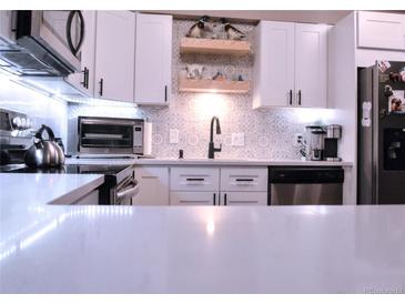 Modern kitchen featuring stainless steel appliances and beautiful backsplash design at 650 S Clinton St # 2A, Denver, CO 80247