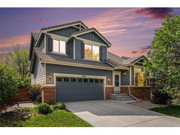 Charming two-story home featuring a two-car garage, brick accents, and professional landscaping at 10647 Nucla St, Commerce City, CO 80022