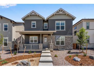 Charming two-story home with gray siding, stone accents, and a cozy front porch at 24851 E 33Rd Dr, Aurora, CO 80019