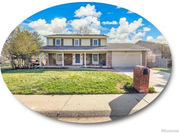 Traditional two-story home with a brick facade, covered porch, and well-manicured lawn at 3790 E Geddes Ave, Centennial, CO 80122