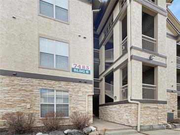 Condominium exterior showcasing stone accents, neutral stucco, and stairs to upper levels at 7483 S Quail Cir # 635, Littleton, CO 80127