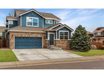 Charming two-story home featuring a brick and blue wood facade, a two-car garage, and a well-manicured lawn at 16191 E Hinsdale Ln, Aurora, CO 80016