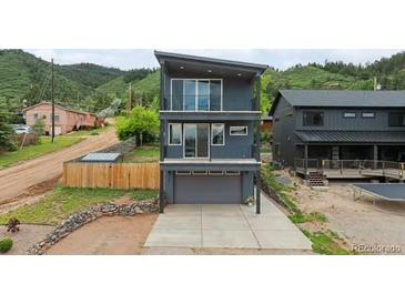 Contemporary three-story home featuring balconies and a mountain backdrop at 260 Upper Glenway Rd, Palmer Lake, CO 80133