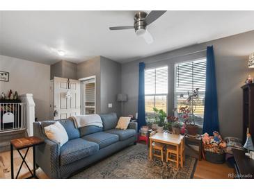 Cozy living room with hardwood floors, comfortable seating and a view to the front door at 126 Foxglove Dr, Brighton, CO 80601