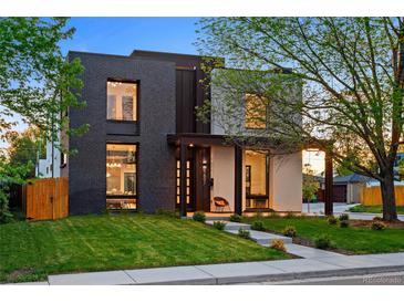 Striking modern two-story home with dark brick and light stucco, accented by lush green lawn and mature trees at 1601 S Columbine St, Denver, CO 80210
