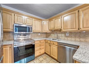 Bright kitchen features stainless steel appliances and light wood cabinets at 6940 E Girard Ave # 203, Denver, CO 80224