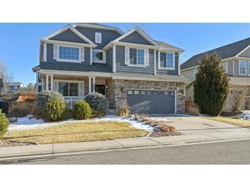 Two-story house with gray siding, stone accents, and a two-car garage at 15008 Clayton St, Thornton, CO 80602