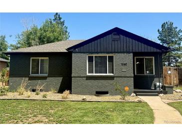 Charming front exterior of a brick home featuring manicured lawn, modern windows and inviting entry at 1560 Quince St, Denver, CO 80220