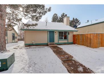 Cute house exterior with snowy yard, walkway, and wood fence at 3742 S Danube Cir, Aurora, CO 80013