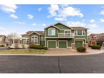 Inviting townhouse featuring a three-car garage, balcony, and charming architectural details at 19437 E Mann Creek Dr # A, Parker, CO 80134