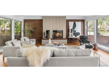 Inviting living room with brick fireplace, stylish furniture, and abundant natural light at 8955 E 19Th Ave, Aurora, CO 80010