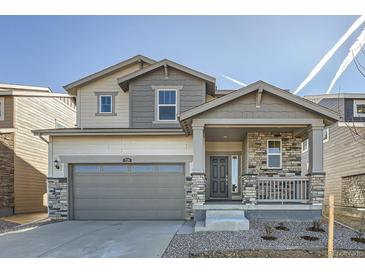 Charming two-story home with stone accents, covered porch, and two car garage at 728 N Clubview St, Watkins, CO 80137