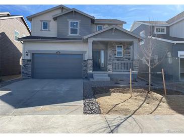 Charming two-story home featuring a stone facade and a two-car garage at 728 N Clubview St, Watkins, CO 80137