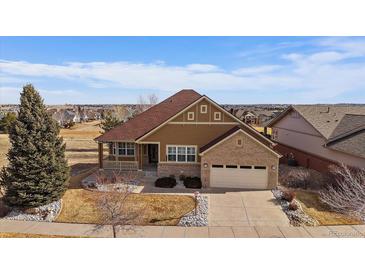 Charming two-story home with a well-maintained lawn and attached two-car garage and covered porch at 21753 E Heritage Pkwy, Aurora, CO 80016