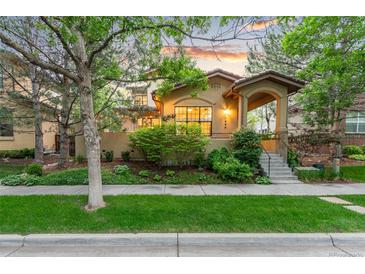 Charming stucco home featuring manicured landscaping, covered entryway, and inviting curb appeal at 7444 E 9Th Ave, Denver, CO 80230