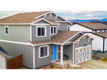 Charming two-story home featuring a welcoming blue door and mountain views in the background at 605 Wild Honey Dr, Berthoud, CO 80513