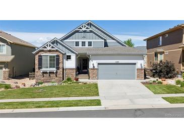 Charming two-story home featuring stone accents, a well-manicured lawn, and an attached two-car garage at 12189 Windy Trail Ln, Parker, CO 80138