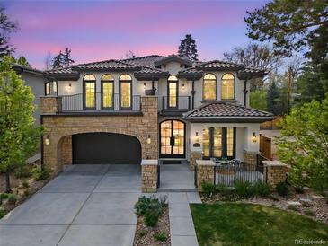 Elegant home with a stone archway garage, charming balconies, and manicured lawn at 455 Forest St, Denver, CO 80220