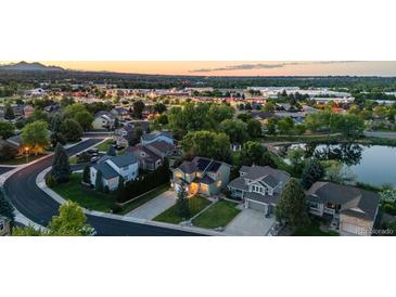 Gorgeous aerial view of a residential neighborhood with well-maintained homes and tree-lined streets near a pond at 6266 Holman St, Arvada, CO 80004