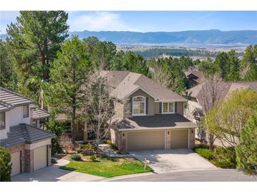 Inviting two-story home with a three-car garage and well-manicured front yard with mountain views at 3315 Klondike Pl, Castle Rock, CO 80108