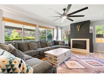 Inviting living room features a fireplace and a large window with a view of the backyard at 8288 W Chestnut Ave, Littleton, CO 80128