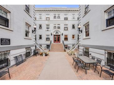 Charming white brick building with red doors and a lovely outdoor seating area at 215 E 11Th Ave # C3, Denver, CO 80203