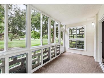 The sunroom offers large windows with expansive green outdoor views and a private entry at 650 S Alton Way # 10A, Denver, CO 80247