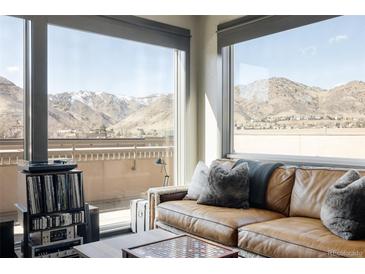 Comfortable living room with a leather couch and stunning views of the mountains from the expansive windows at 1275 Washington Ave, Golden, CO 80401