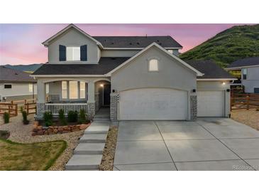 Charming two-story home featuring a three-car garage, inviting porch, and beautiful, low-maintenance landscaping at 5446 Mesa Top Dr, Monument, CO 80132