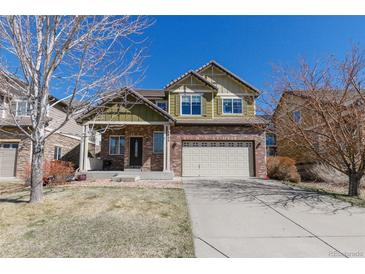 Charming two-story home featuring brick accents, a well-maintained lawn, and an attached two-car garage at 6852 S Algonquian Ct, Aurora, CO 80016