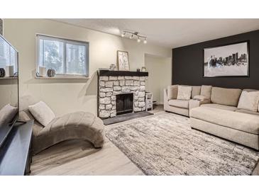 Inviting living room featuring a stone fireplace, neutral color palette, and comfortable seating arrangement at 4068 S Atchison Way # 101, Aurora, CO 80014