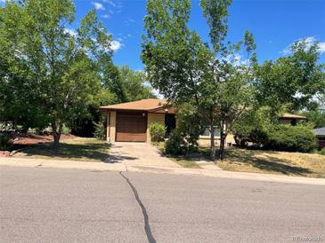Charming single-story home with a driveway, mature trees, and a well-maintained lawn at 6139 S Adams Dr, Centennial, CO 80121