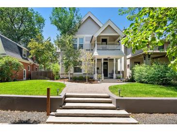 Inviting two-story home featuring a covered front porch and meticulously maintained lawn at 321 S Emerson St, Denver, CO 80209