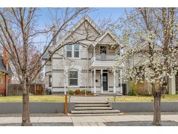 Charming two-story home with a welcoming front porch and beautifully landscaped front yard at 321 S Emerson St, Denver, CO 80209
