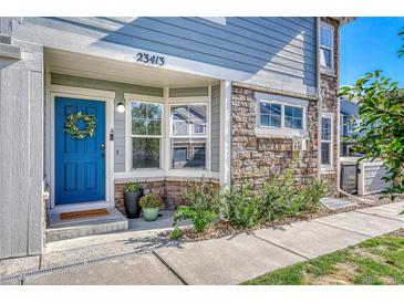 Charming townhome entrance features a blue door, stone accents, and well-maintained landscaping at 23413 E Dorado Pl # A, Aurora, CO 80016