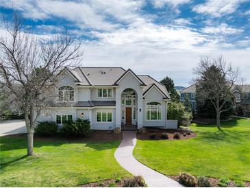 Stunning two-story home with arched entry, well-manicured lawn, and beautiful landscaping at 8 Mountain Willow Dr, Littleton, CO 80127