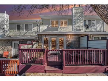 A cozy back porch with a maroon wood fence and doors that lead into the house at 5252 W 68Th Ave, Arvada, CO 80003