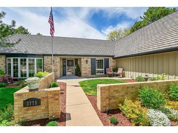 Charming brick home with well-manicured lawn, beautiful landscaping, and cozy outdoor seating area at 3775 S Poplar St, Denver, CO 80237