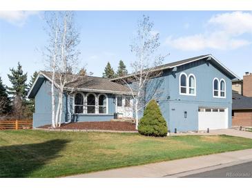 Charming two-story blue home with landscaped front yard and attached two car garage at 10795 E Powers Dr, Englewood, CO 80111