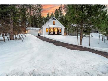 Charming Craftsman home with snowy front yard and attached garage at 950 Tenderfoot Dr, Larkspur, CO 80118
