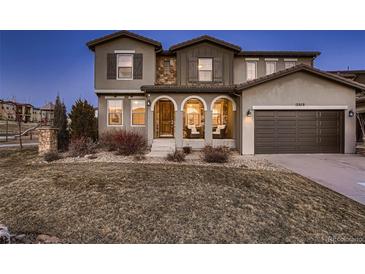 Charming home featuring a covered porch with stone accents and a two-car garage at 2618 S Kilmer Ct, Denver, CO 80228