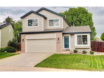 Charming two-story home with a well-manicured lawn, attached garage, and inviting blue trim at 21486 E Crestline Ln, Centennial, CO 80015
